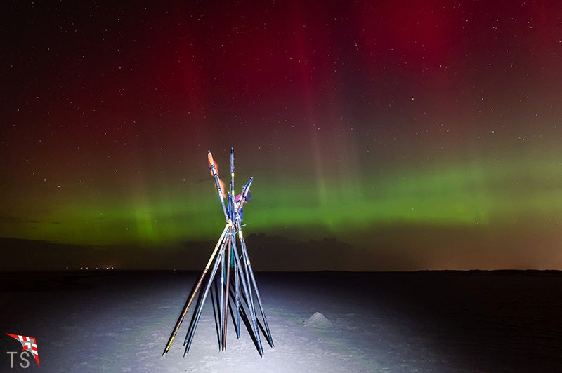 Polarlichter mit Fischerstangen am Strand